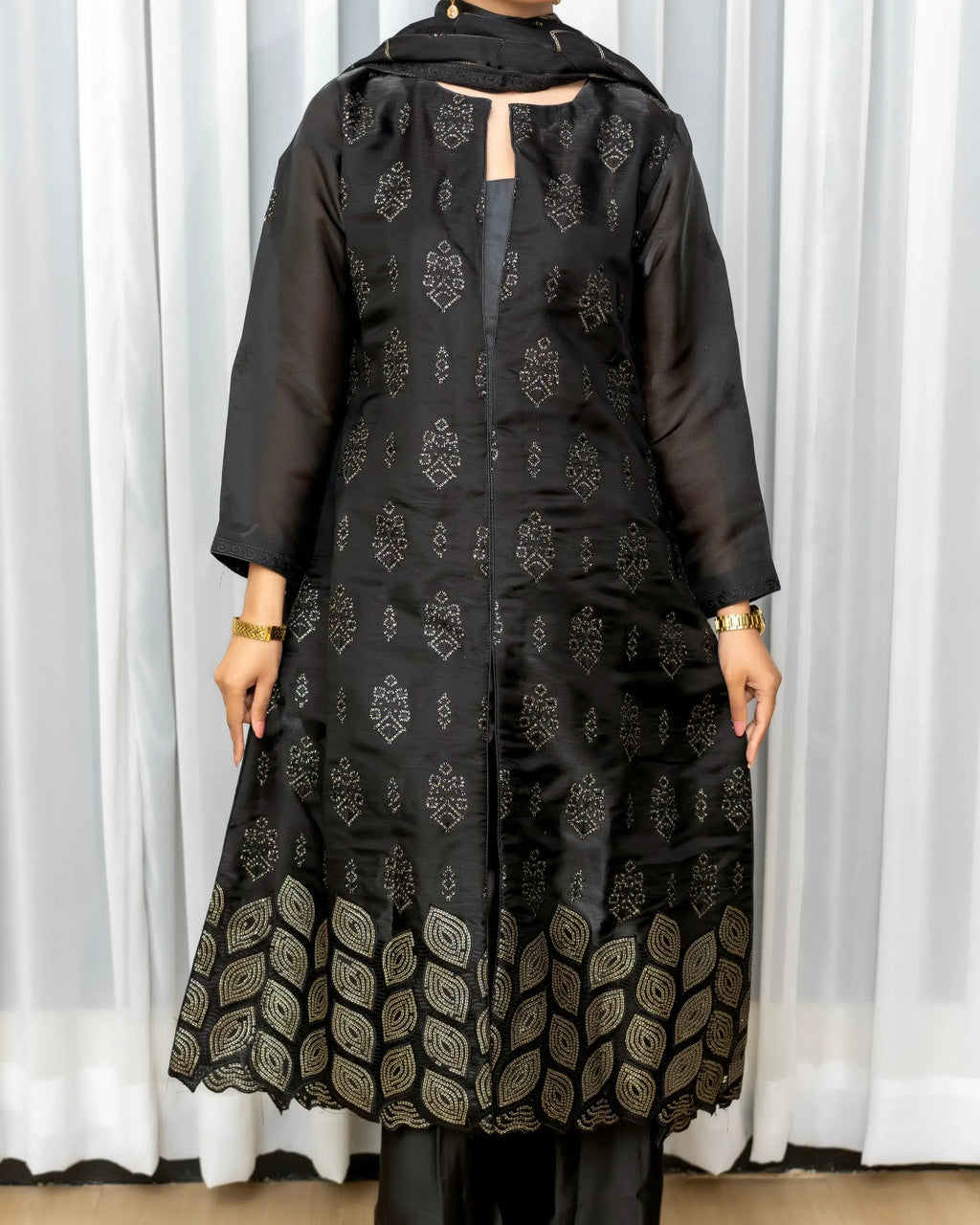 Black embroidered outfit with a plain background