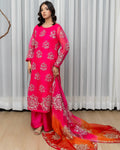 Woman wearing a pink traditional outfit with white patterns against a white curtain background