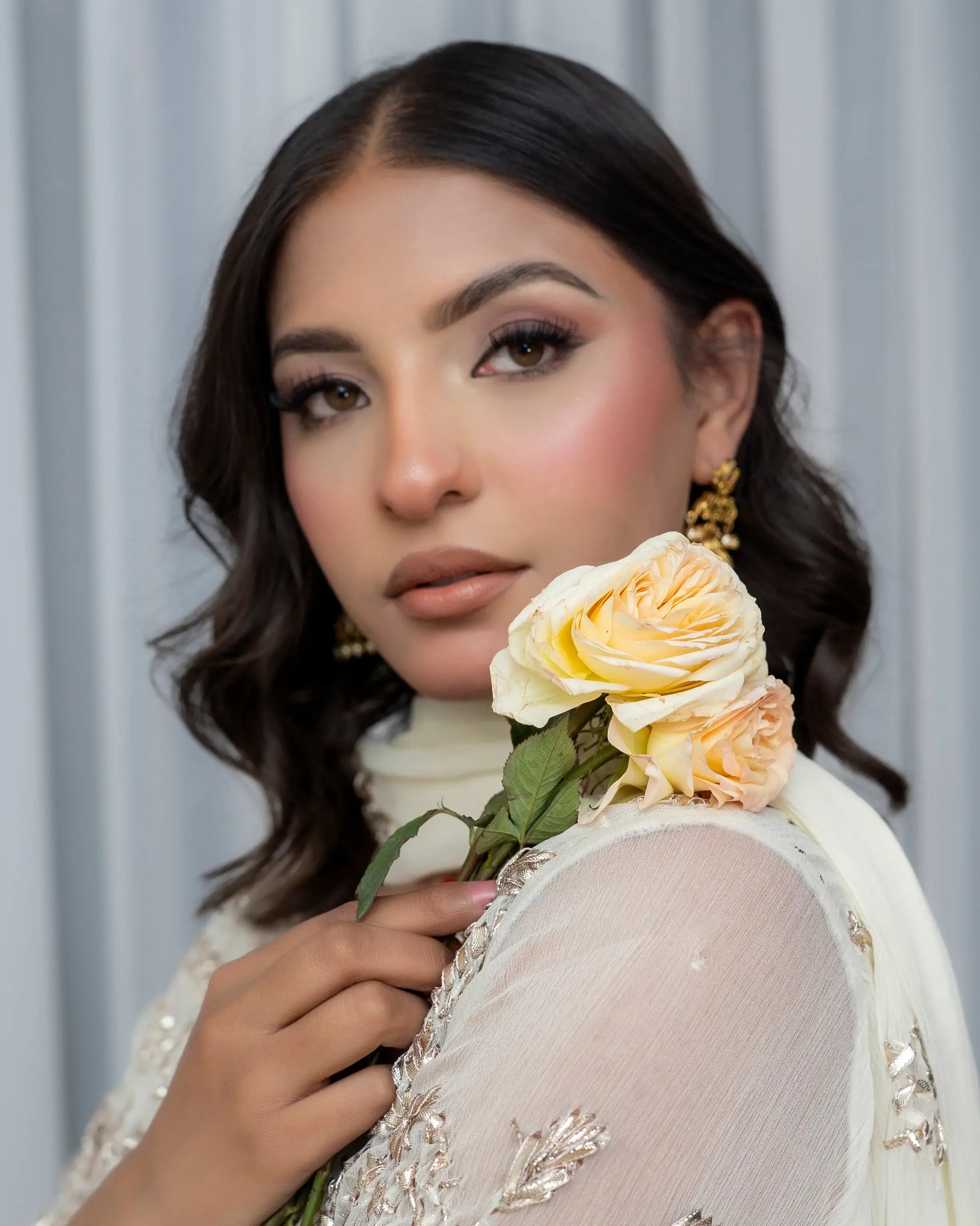 Woman holding a bouquet of flowers against a neutral background